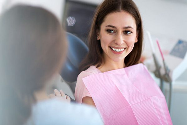 woman smiling while sitting in the dental chair